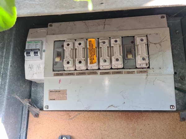 An older switchboard fitted with ceramic rewireable fuses inside a metal enclosure