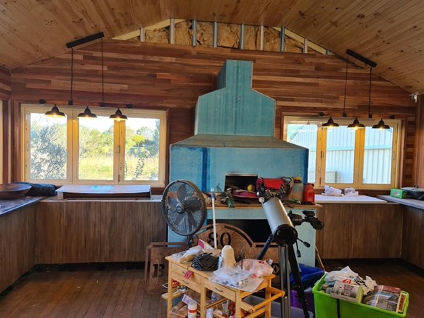 A timber-lined kitchen with pendant lights hanging over the bench