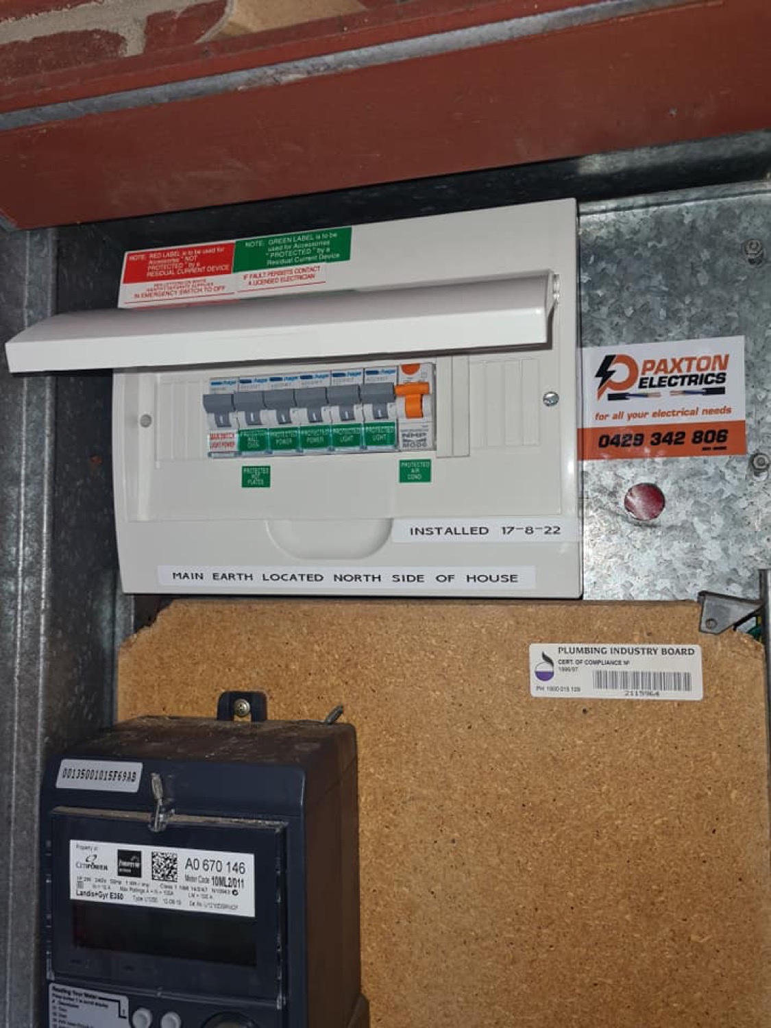 A switchboard carrying a Paxton Electrics sticker above a wall-mounted meter