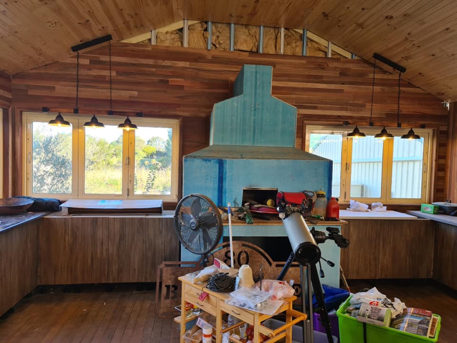 A timber-lined kitchen with pendant lights hanging over the bench